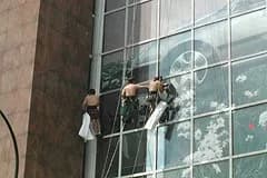 Cordistes TRAPEZE posant l'affiche géante de la Peugeot 607 sur une façade