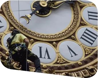 Cordiste TRAPEZE qui dépoussière l'horloge du musée d'Orsay